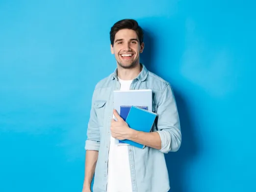 Estudante sorrindo com cadernos nas mãos